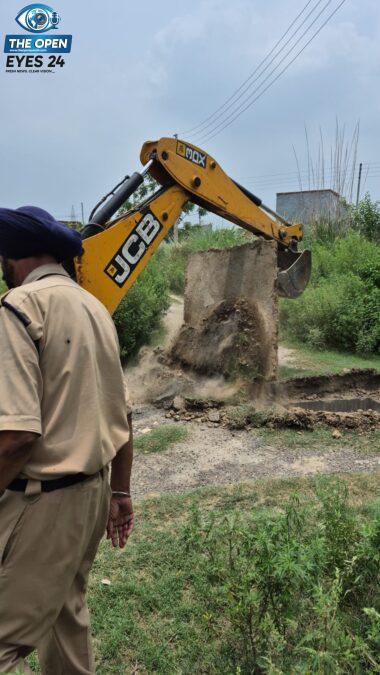 ਪਿੰਡ ਖਾਸੀ ਕਲਾਂ ਵਿਖੇ ਅਣਅਧਿਕਾਰਤ ਕਲੋਨੀ ਦੀਆਂ ਗੈਰ-ਕਾਨੂੰਨੀ ਉਸਾਰੀਆਂ ਅਤੇ ਸੜਕਾਂ ਨੂੰ ਬੁਲਡੋਜ਼ਰ ਦੀ ਮਦਦ ਨਾਲ ਜ਼ਮੀਨਦੋਜ਼ ਕਰਦੀ ਹੋਈ ਗਲਾਡਾ ਦੀ ਟੀਮ।
